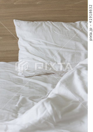 Messy white bed and two pillow, in the morning. 41918632