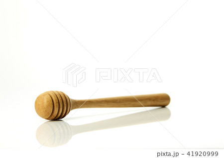 Honey dripping from a wooden honey dipper 41920999