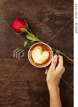 The hand of a young woman holding a red coffee The hand of a young woman holding a red coffee 41921334