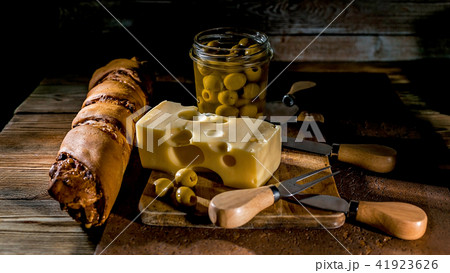 Cheese, olives and baguette. Low key lighting Cheese, olives and baguette. Low key lighting 41923626