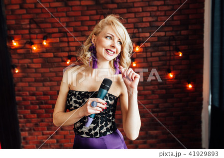 beautiful girl leading holding a microphone and smiling 41929893