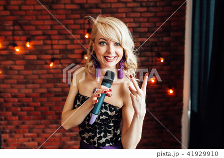 beautiful girl leading holding a microphone and smiling beautiful girl leading holding a microphone and smiling 41929910