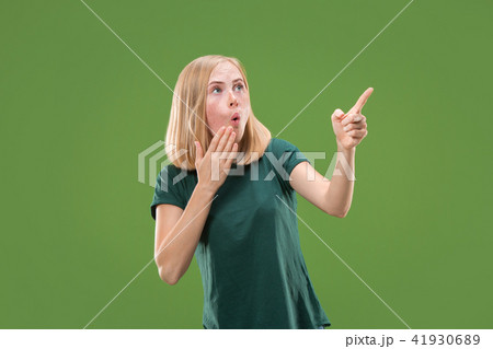 Beautiful woman looking suprised isolated on green 41930689