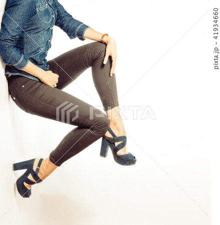 Girl in black high heels and gray jeans. Lower half body on gray background. Girl in black high heels and gray jeans. Lower half body on gray background. 41934660