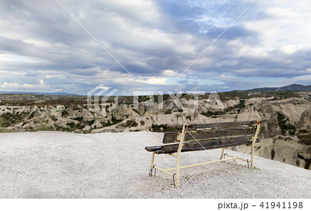 A wooden weathered bench stands against  41941198