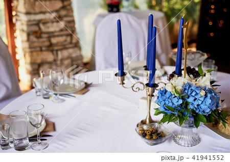Table with a classic design. With a composition in a high vase with hydrangeas and lilies, a Golden Table with a classic design. With a composition in a high vase with hydrangeas and lilies, a Golden 41941552