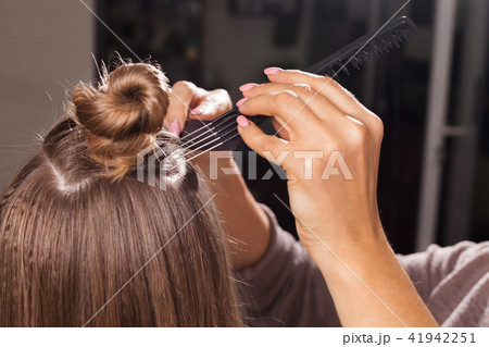 hairdresser making a coiffure with a bun 41942251