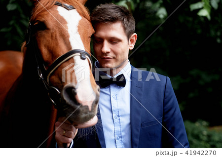 Wedding romantic walk of the bride and groom.Brown horse.Portrait of groom Wedding romantic walk of the bride and groom.Brown horse.Portrait of groom 41942270