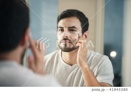 Young Man Applying Anti-aging Lotion fot Skin Care Young Man Applying Anti-aging Lotion fot Skin Care 41943380