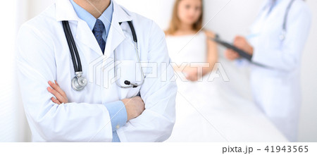 Doctor man standing straight in hospital. Closeup of stethoscope at practitioner breast. Medicine 41943565