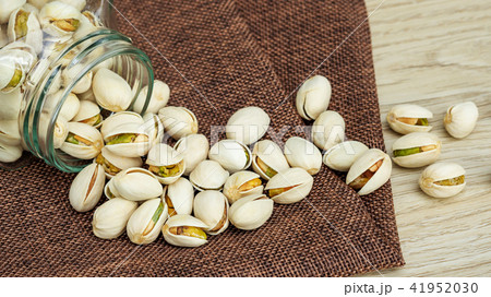 Pistachio nuts on a wooden table. 41952030
