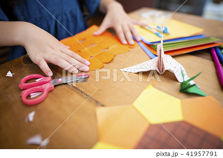 折り紙で遊ぶ女の子の写真素材