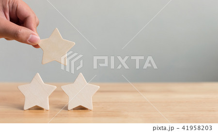 Hand putting wooden five star shape on table 41958203