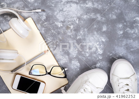 Top view of travel stuff. Essential travel items. shoes, smart phone, notebook, sun glasses on stone Top view of travel stuff. Essential travel items. shoes, smart phone, notebook, sun glasses on stone 41962252