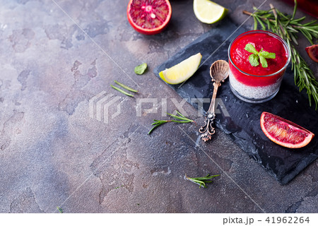 Chia pudding with fresh berries puree and honey with slice citrus on slate dark background Chia pudding with fresh berries puree and honey with slice citrus on slate dark background 41962264