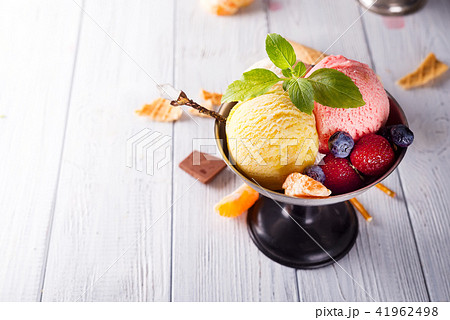 Homemade Organic Vanilla Ice Cream with Mint and ice berries on wooden background Homemade Organic Vanilla Ice Cream with Mint and ice berries on wooden background 41962498