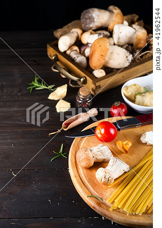 Ingredients for cooking Italian pasta - spaghetti, tomatoes, mushrooms and greens at dark wooden 41962544