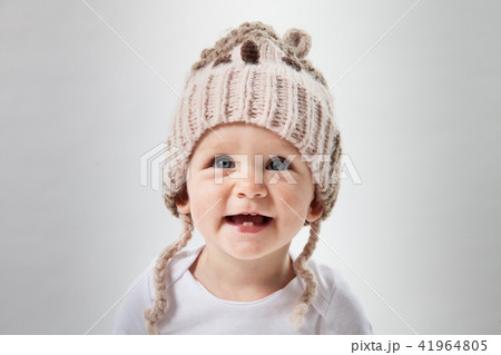 Portrait of a cute baby girl in a huge brown knitted hat. Isolated on white background. 41964805