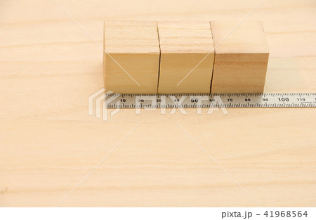 木の板の上に置かれた立方体の木材と金属製の定規(直尺)。 41968564