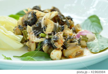 spicy golden apple snail with herb salad on plate 41968984