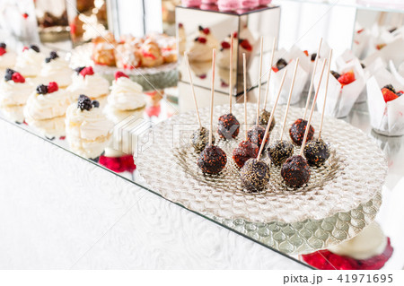 Candy bar with a lot of desserts, meringue, cupcake, fruit and sweet cakes. Sweet table for birthday 41971695