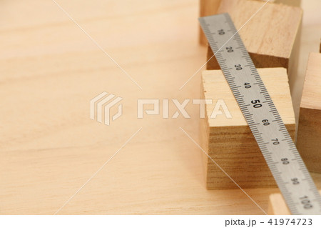 木の板の上に置かれた立方体の木材と金属製の定規(直尺)。 41974723