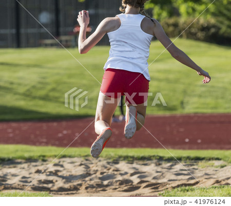 High school female in the air during triple jump 41976124