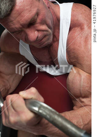 Strong bodybuilder working out with dumbbells 41976927