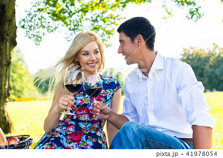Couple having picnic wit red wine on meadow Couple having picnic wit red wine on meadow 41978054