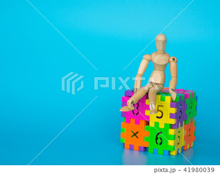 Wooden puppet sitting on cube plastic colorful Wooden puppet sitting on cube plastic colorful 41980039