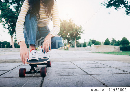 Young teen girl on longboard in the city. Young teen girl on longboard in the city. 41982802