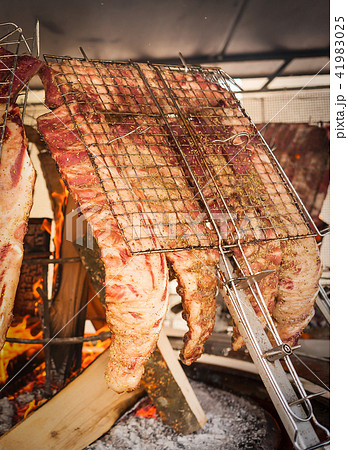 Roasted meat of beef cooked on a vertical grills. 41983025