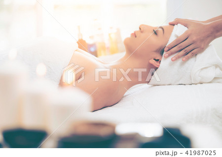 Relaxed woman gets facial and head massage in spa. Relaxed woman gets facial and head massage in spa. 41987025