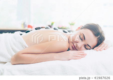 Hot stone massage treatment by therapist in spa. Hot stone massage treatment by therapist in spa. 41987026