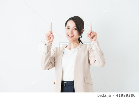 両手の人差し指を上げるポーズのスーツ女性 41989386
