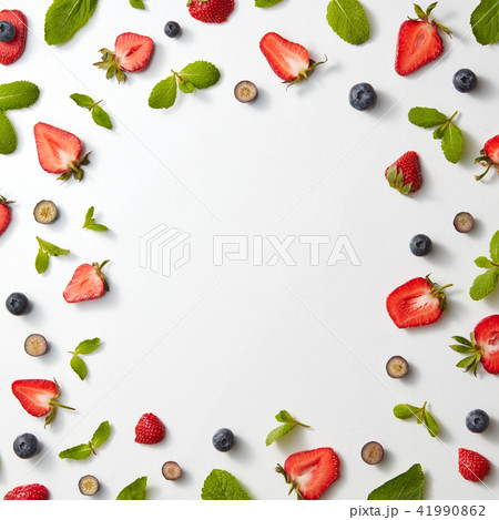 A pattern of strawberries and blueberries with mint on a gray background. Berry frame. Flat lay 41990862