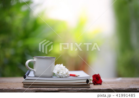 White cup and notebook with white rose White cup and notebook with white rose 41991485