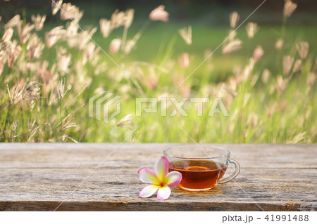 Red tea and frangipani flower on wooden table Red tea and frangipani flower on wooden table 41991488