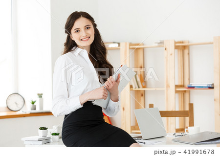 Happy young business woman or secretary holding document in modern office 41991678