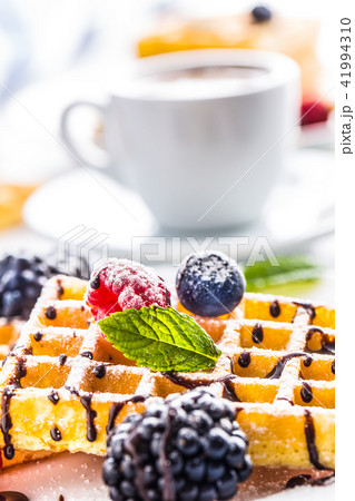 Fresh waffles with chocolate syrup and berries. Fresh waffles with chocolate syrup and berries. 41994310