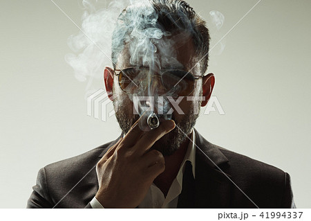 The barded man in a suit holding cigar The barded man in a suit holding cigar 41994337