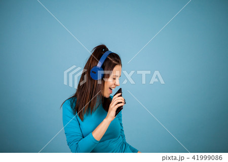 Cute young woman singing on her phone while dancing 41999086