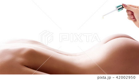Cosmetics oil applying on sexy female buttocks. 42002950