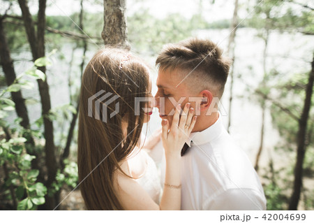 Wedding couple man, bride kissing and hugging on a background of the river, mountains. Beauty 42004699