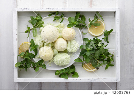 Handmade mint bath bombs with fresh herbs in white tray Handmade mint bath bombs with fresh herbs in white tray 42005763