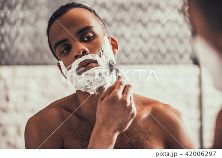 Afro-American Man Shaving in Bathroom at Morning. 42006297