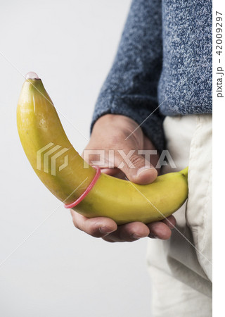 man holding a banana with a condom 42009297