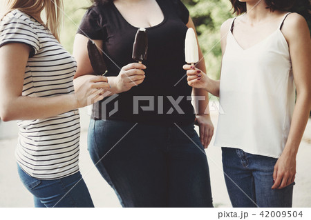 Overweight and fit women eating ice cream Overweight and fit women eating ice cream 42009504