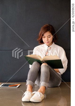 Pretty asian girl reading a book. Pretty asian girl reading a book. 42009638