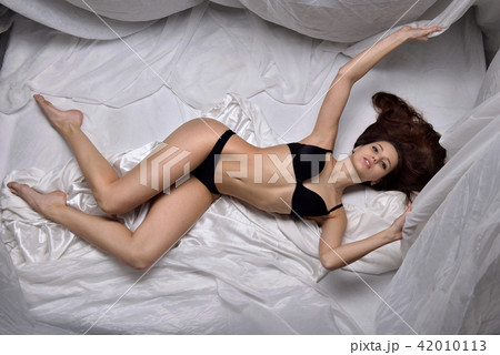 Beautiful woman in black underwear laying on the bed. 42010113